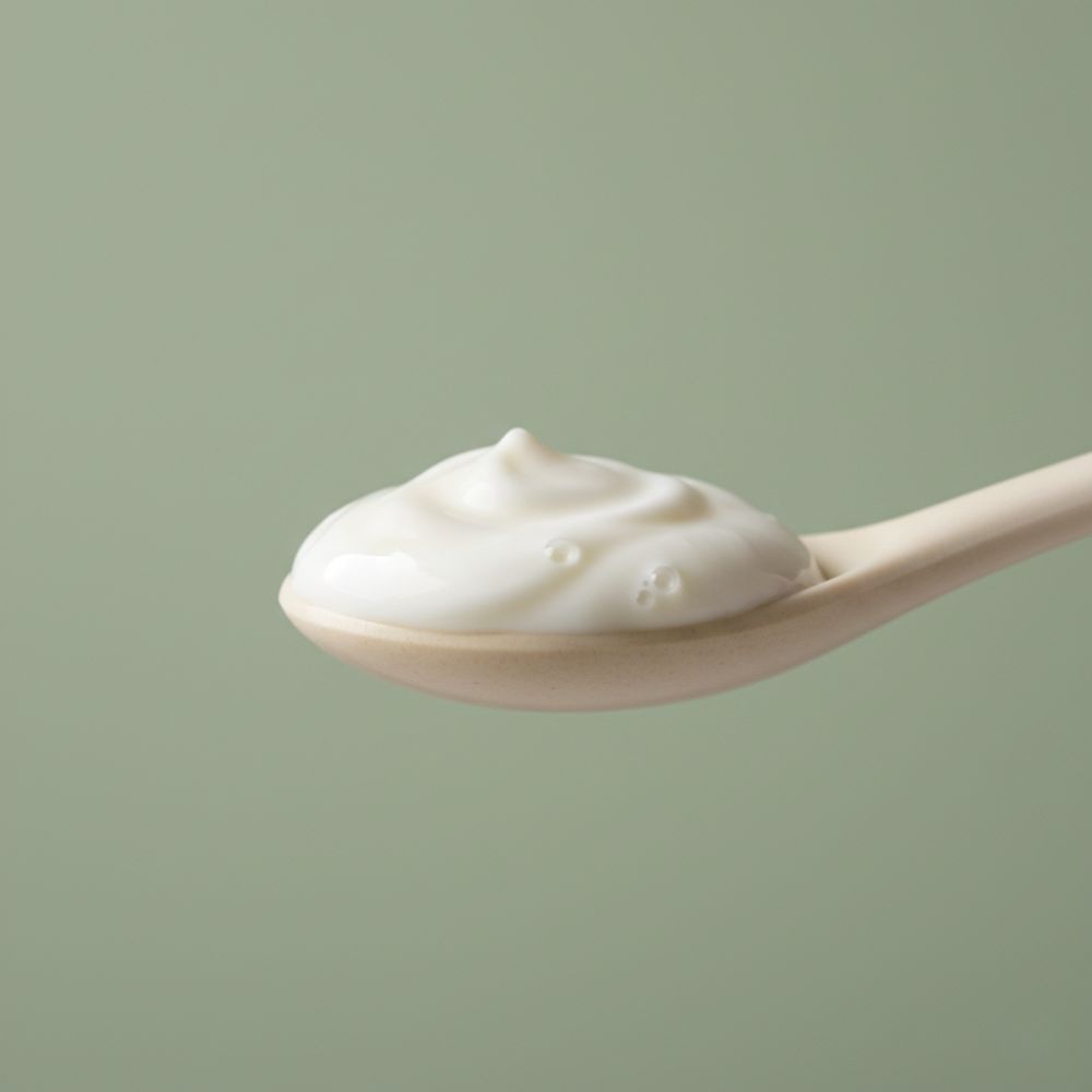 A wooden spoon with a dollop of yogurt
