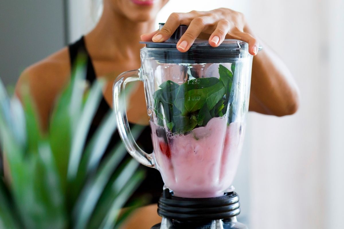 Woman using a blender to make a smoothie.